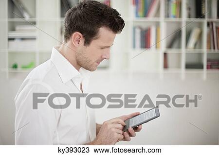 Man using an electronic book View Large Photo Image Stock Image - Man using an electronic book. Fotosearch