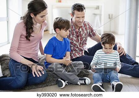 Parents looking at their children using a digital tablet View Large Photo Image Stock Image - Parents looking at their children using a digital tablet. Fotosearch