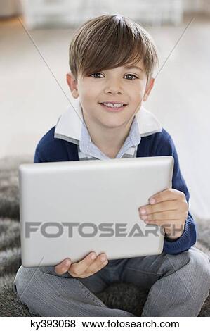 Portrait of a boy holding a digital tablet View Large Photo Image Stock Photo - Portrait of a boy holding a digital tablet. Fotosearch