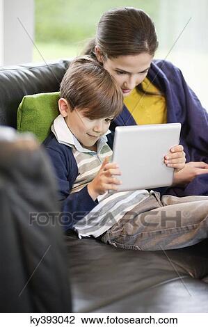 Woman and her son looking at a digital tablet View Large Photo Image Stock Image - Woman and her son looking at a digital tablet. Fotosearch