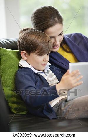 Woman and her son looking at a digital tablet View Large Photo Image Stock Photo - Woman and her son looking at a digital tablet. Fotosearch