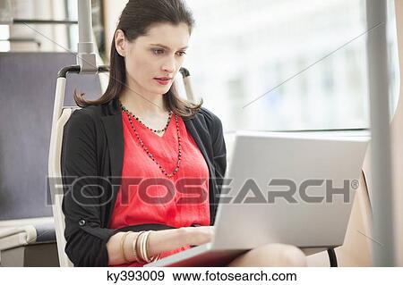 Woman traveling in a bus and using a laptop View Large Photo Image Stock Photo - Woman traveling in a bus and using a laptop. Fotosearch