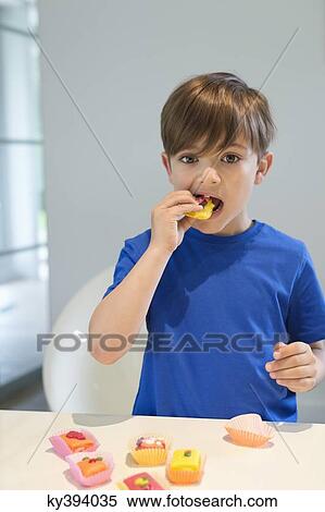 Boy eating a cup cake View Large Photo Image Stock Photography - Boy eating a cup cake. Fotosearch