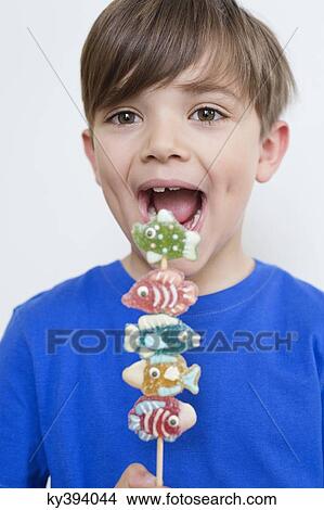 Boy eating candies View Large Photo Image Picture - Boy eating candies. Fotosearch