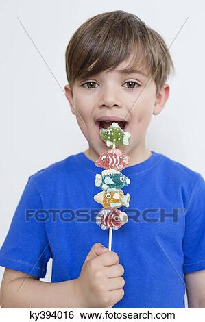 Stock Photograph - Boy eating candies. Fotosearch