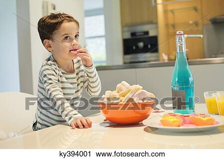 Stock Image - Boy eating snack. Fotosearch