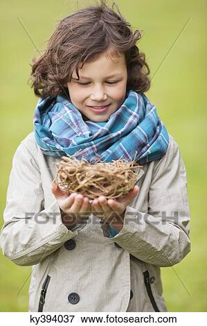 Stock Photo - Boy holding a bird's nest. Fotosearch