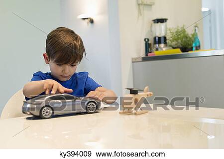 Boy playing with a toy car View Large Photo Image Stock Photo - Boy playing with a toy car. Fotosearch
