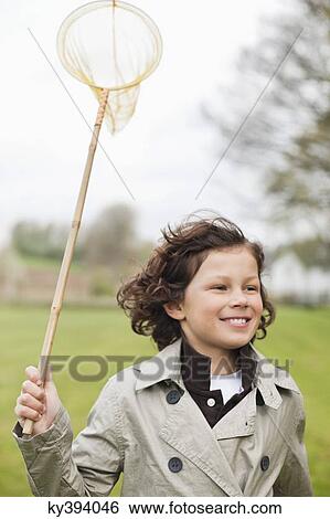 Boy running with a butterfly net in a park View Large Photo Image Stock Photograph - Boy running with a butterfly net in a park. Fotosearch