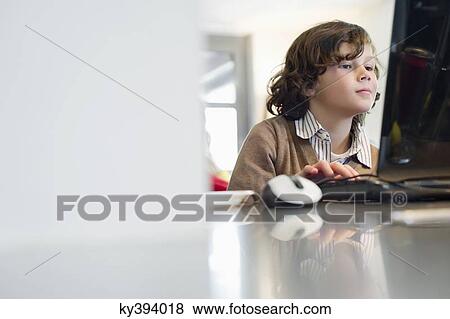 Boy using a laptop View Large Photo Image Stock Photo - Boy using a laptop. Fotosearch