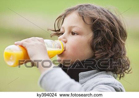 Close-up of a boy drinking juice View Large Photo Image Picture - Close-up of a boy drinking juice. Fotosearch