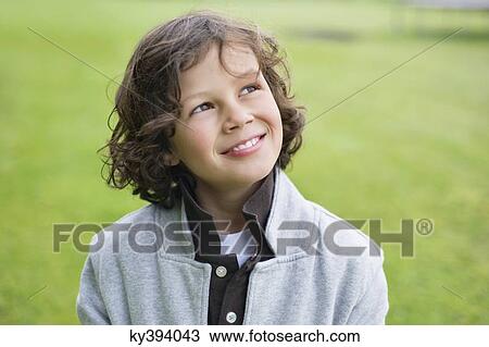 Close-up of a boy smiling in a field View Large Photo Image Stock Image - Close-up of a boy smiling in a field. Fotosearch