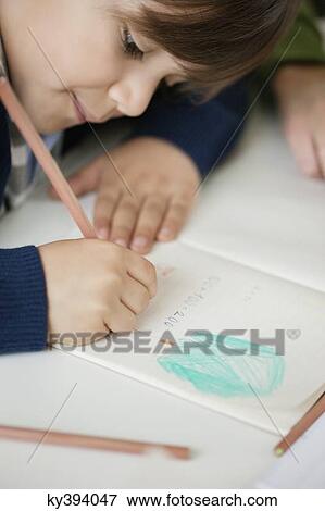 Close-up of a boy studying View Large Photo Image Stock Photo - Close-up of a boy studying. Fotosearch