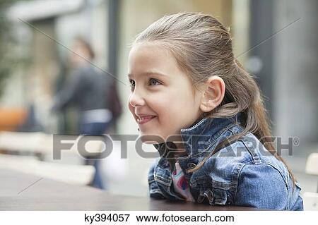 Stock Photo - Close-up of a girl sitting at a sidewalk cafe. Fotosearch