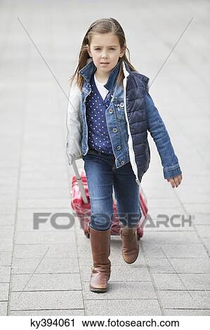 Girl pulling her luggage View Large Photo Image Stock Image - Girl pulling her luggage. Fotosearch