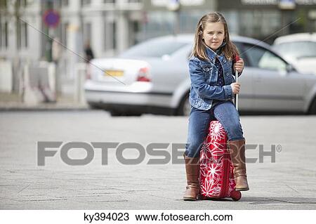 Girl sitting on her luggage View Large Photo Image Stock Image - Girl sitting on her luggage. Fotosearch