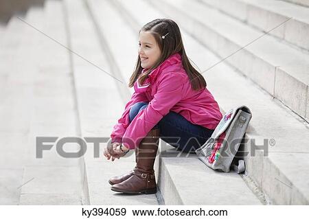Stock Photo - Girl sitting on the steps and smiling. Fotosearch