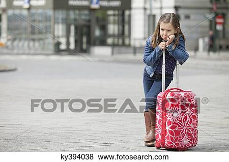 Stock Photo - Girl standing with her luggage. Fotosearch