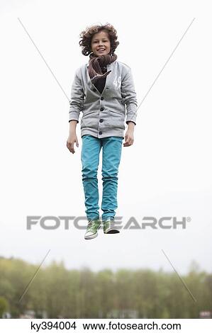 Portrait of a boy jumping in a field View Large Photo Image Picture - Portrait of a boy jumping in a field. Fotosearch