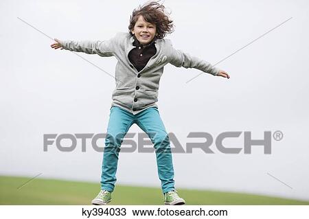 Portrait of a boy jumping in a field View Large Photo Image Stock Image - Portrait of a boy jumping in a field. Fotosearch