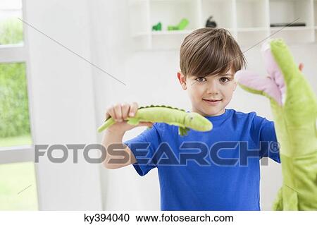 Stock Image - Portrait of a boy playing with animals toys. Fotosearch