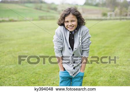 Portrait of a boy smiling in a field View Large Photo Image Stock Photo - Portrait of a boy smiling in a field. Fotosearch