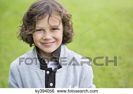 Portrait of a boy smiling in a field View Large Photo Image Stock Photograph - Portrait of a boy smiling in a field. Fotosearch