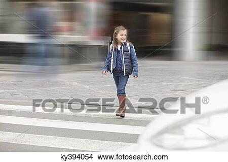 Schoolgirl crossing a road View Large Photo Image Picture - Schoolgirl crossing a road. Fotosearch
