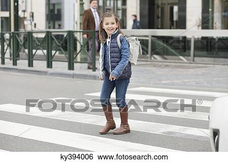 Schoolgirl crossing a road View Large Photo Image Stock Photograph - Schoolgirl crossing a road. Fotosearch