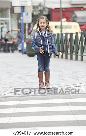 Schoolgirl standing at the roadside View Large Photo Image Stock Photo - Schoolgirl standing at the roadside. Fotosearch