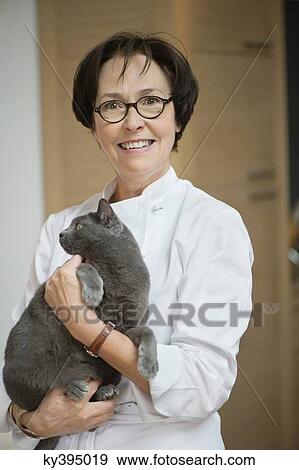 Woman holding a cat and smiling View Large Photo Image Stock Photo - Woman holding a cat and smiling. Fotosearch