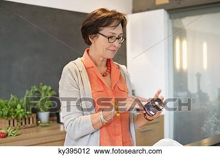 Woman reading label on a bottle View Large Photo Image Stock Image - Woman reading label on a bottle. Fotosearch