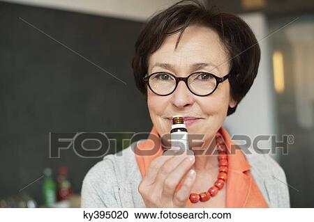 Stock Image - Woman smelling aromatherapy oil. Fotosearch