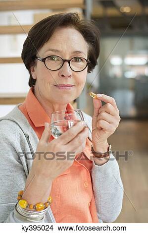 Picture - Woman taking medicine. Fotosearch