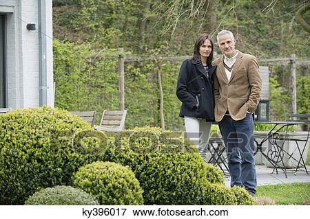 Couple standing in a garden View Large Photo Image Stock Photo - Couple standing in a garden. Fotosearch