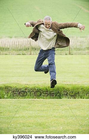 Man jumping in a field View Large Photo Image Picture - Man jumping in a field. Fotosearch