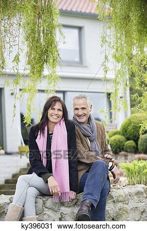 Romantic couple sitting in a garden and smiling View Large Photo Image Stock Image - Romantic couple sitting in a garden and smiling. Fotosearch