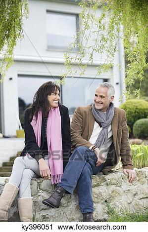 Romantic couple sitting in a garden and smiling View Large Photo Image Stock Image - Romantic couple sitting in a garden and smiling. Fotosearch
