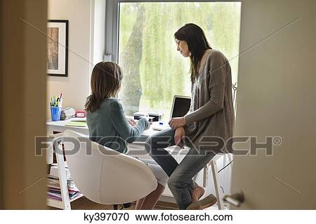 Girl studying with her mother at home View Large Photo Image Stock Image - Girl studying with her mother at home. Fotosearch