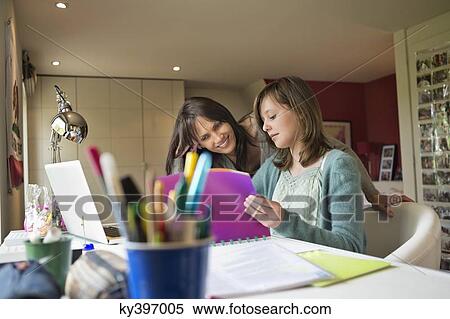 Girl studying with her mother at home View Large Photo Image Stock Photography - Girl studying with her mother at home. Fotosearch
