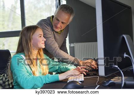 Girl using a computer with her father at home View Large Photo Image Stock Image - Girl using a computer with her father at home. Fotosearch