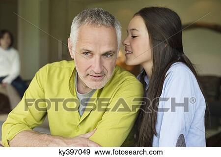 Girl whispering to her father View Large Photo Image Stock Photo - Girl whispering to her father. Fotosearch
