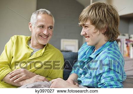 Man and his son smiling at home View Large Photo Image Stock Photo - Man and his son smiling at home. Fotosearch