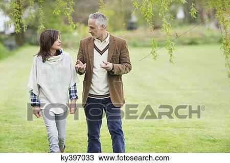 Man discussing with his daughter during walk in a park View Large Photo Image Stock Image - Man discussing with his daughter during walk in a park. Fotosearch