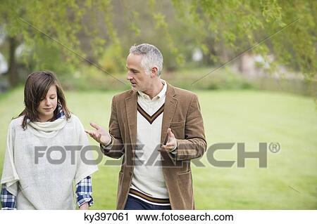 Man discussing with his daughter during walk in a park View Large Photo Image Stock Image - Man discussing with his daughter during walk in a park. Fotosearch
