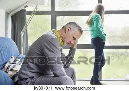 Man looking upset with his daughter standing in the background View Large Photo Image Stock Image - Man looking upset with his daughter standing in the background. Fotosearch