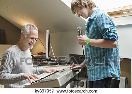 Man playing an electric piano with his son at home View Large Photo Image Stock Photo - Man playing an electric piano with his son at home. Fotosearch