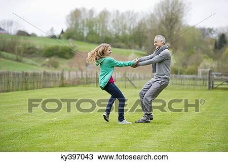 Man playing with his daughter in a field View Large Photo Image Stock Image - Man playing with his daughter in a field. Fotosearch