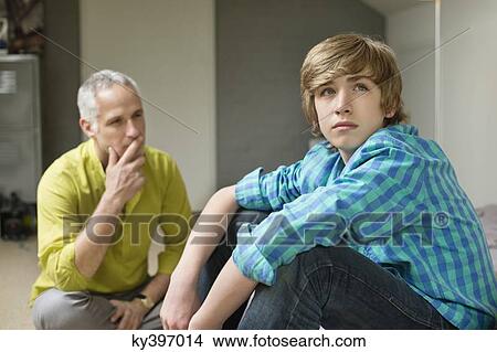 Man sitting with his son looking upset View Large Photo Image Picture - Man sitting with his son looking upset. Fotosearch