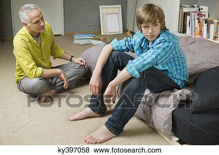 Man sitting with his son looking upset View Large Photo Image Stock Photo - Man sitting with his son looking upset. Fotosearch